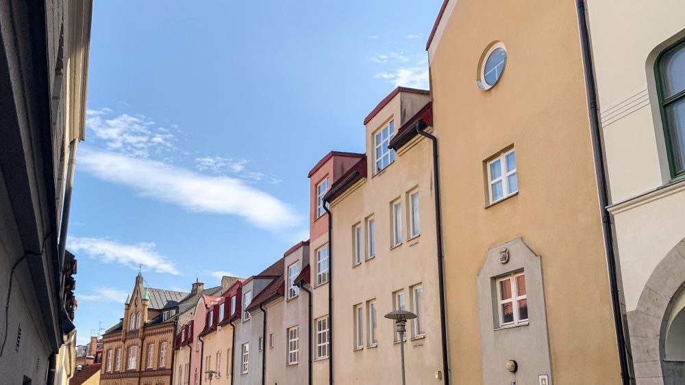 Färgglada fasader på några lägenhetshus och en blå himmel