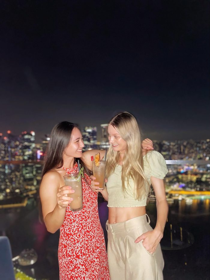 Två kompisar på en rooftop bar i Singapore