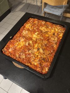 En stor plåt med tillagad lasagne.