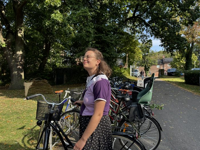 Nicole står vid ett cykelställ och ler.