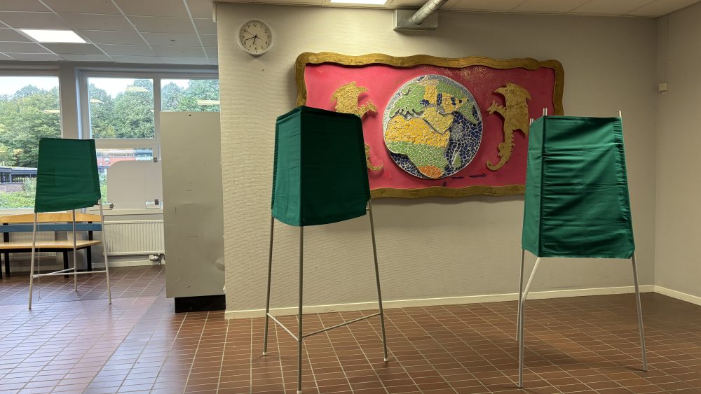 Tre gröna skärmar i en vallokal.